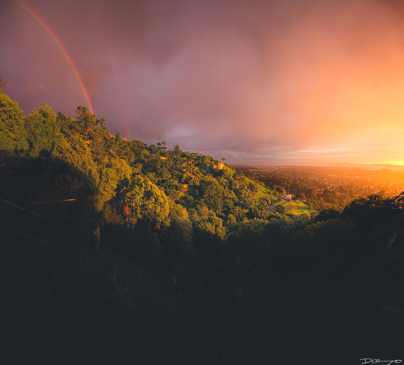 Sunset over the Berkeley Hills, CA. Shot just after a rainstorm, with a double rainbow and glowing golden sunlight illuminating the San Francisco Bay.