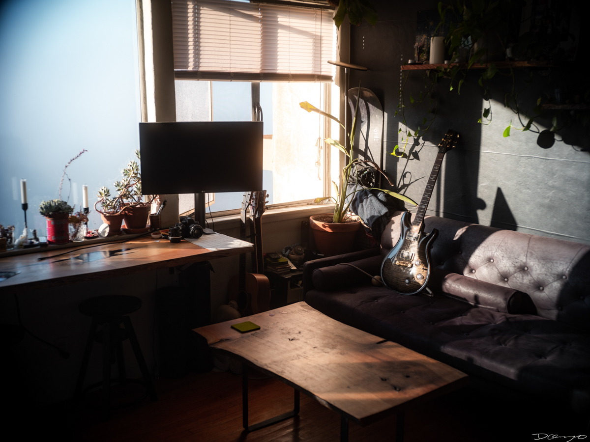 Apartment draped in sunlight in the Berkeley hills with PRS guitar and wooden café style desk.
